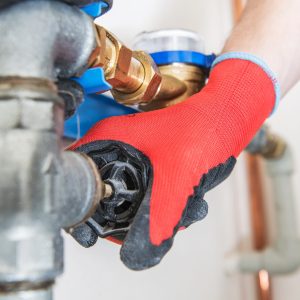 Residential Water Pipeline Valve Closing. Plumbing Industry Concept. Caucasian Plumber Worker.